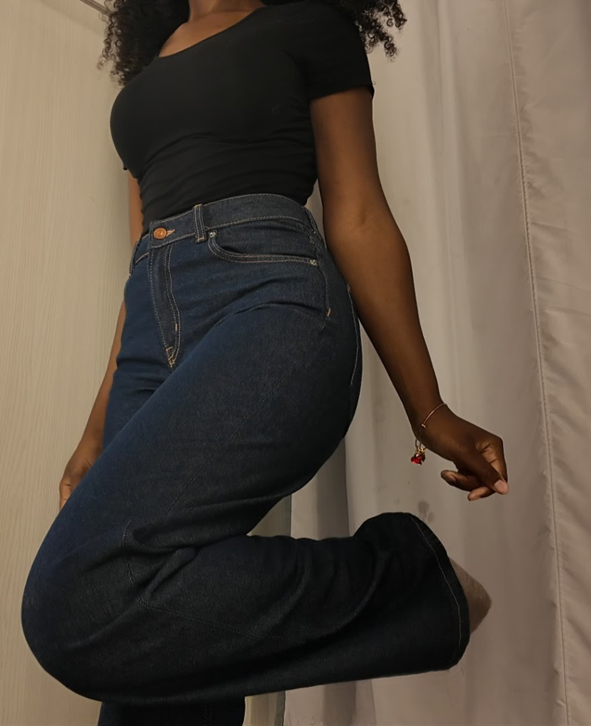 Mya in the fitting room seeing if she enjoys the pants on her.
